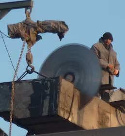 Yüksekte elmas kesim ekipmanı kullanılarak beton elemanın kontrollü şekilde kesilmesi ve vinç desteğiyle güvenli yıkım işlemi