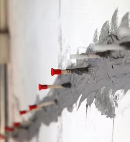 Epoksi enjeksiyon öncesi beton çatlağı boyunca yerleştirilen enjeksiyon nipelleri ve yüzey sızdırmazlık hazırlığı